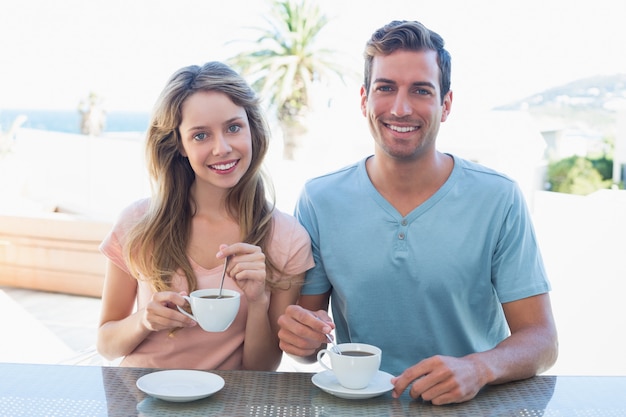 Casal jovem feliz tomando café na mesa