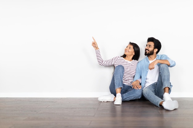 Casal jovem hindu feliz comprando espaço para cópia de casa nova