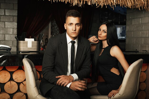 Casal jovem lindo e elegante relaxando em um bar