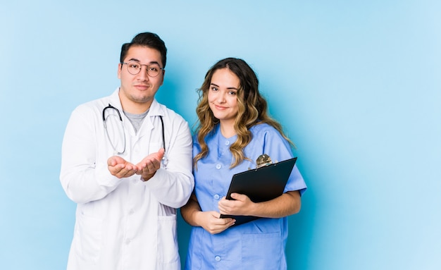 Casal jovem médico posando em azul