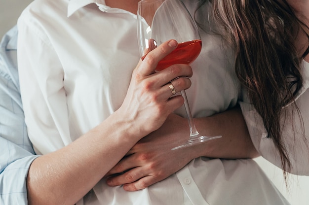 Casal jovem romântico com vinho rosé abraçando