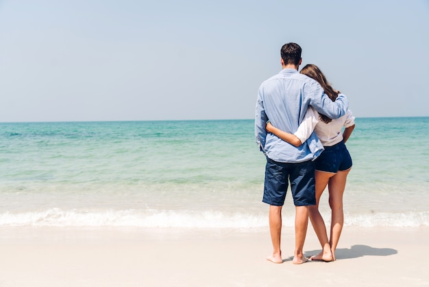 Casal jovem romântico relaxante juntos na praia tropical