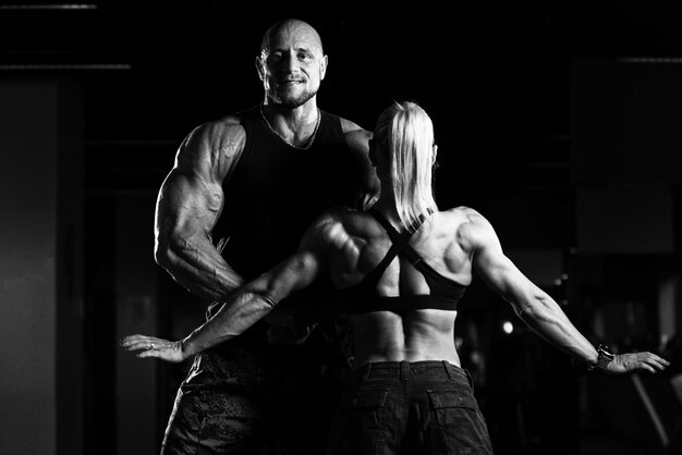 Casal jovem saudável flexionando os músculos