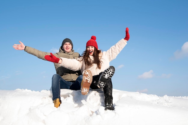 Casal jovem se diverte no dia ensolarado de inverno Férias de inverno Muita neve