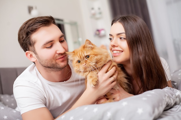 Casal jovem sensual feliz, deitado na cama juntos