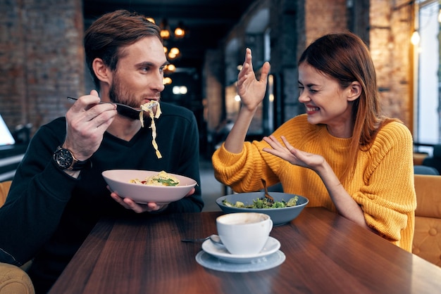 Casal jovem sentado em um restaurante conversando namoro