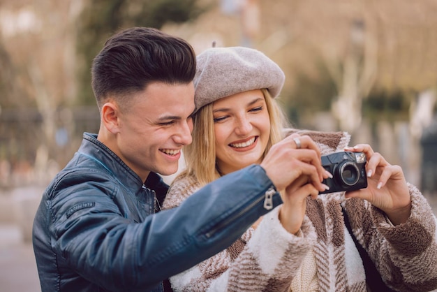 Foto casal jovem turista tira fotos na cidade com câmera vintage