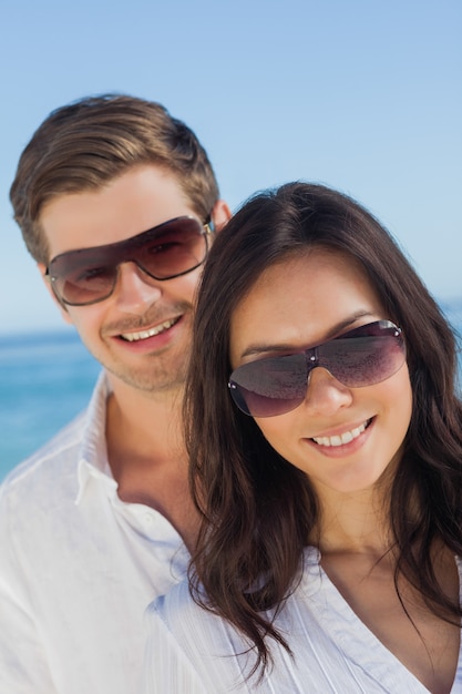 Casal jovem usando óculos de sol e sorrindo