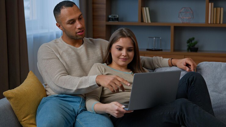 Foto casal latino-americano africano olha para laptop mulher multirracial e homem descansa no sofá família diversa