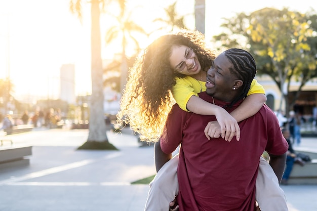 Casal latino se divertindo andando na rua da cidade no feriado - Amigos felizes rindo juntos