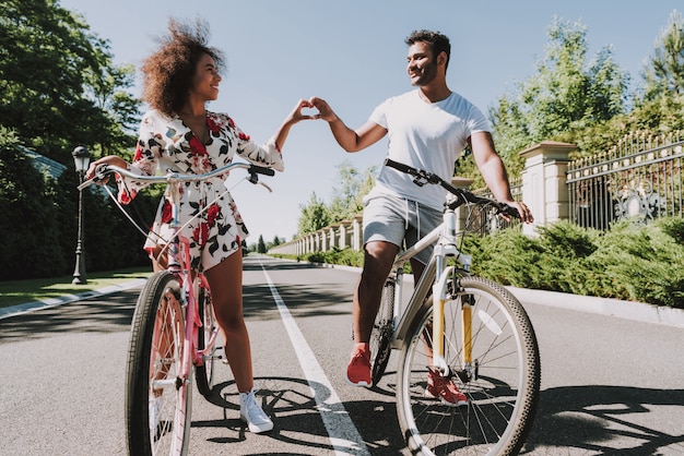 Foto casal latino vai andar de bicicleta e mostrando o dedo coração