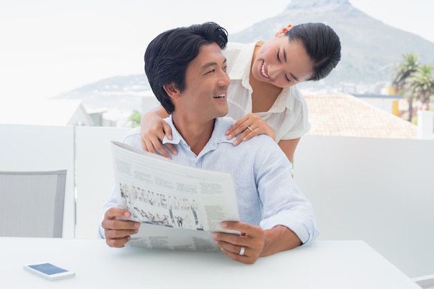 Casal lendo um jornal juntos