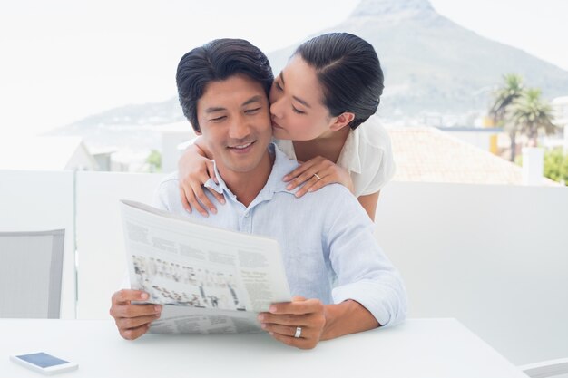 Casal lendo um jornal juntos