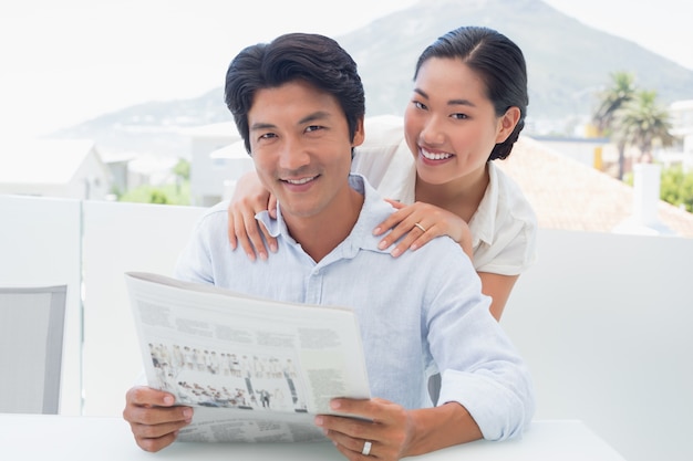 Casal lendo um jornal juntos