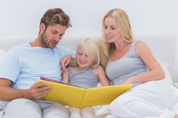 Casal lendo uma história para filha