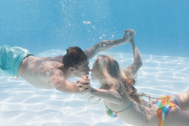 Casal lindo beijando debaixo d&#39;água na piscina