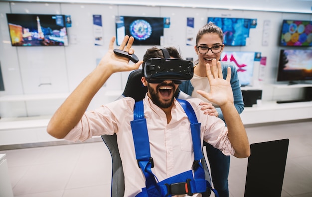 Foto casal lindo hipster jovem se divertindo enquanto verifica vr na loja de tecnologia.