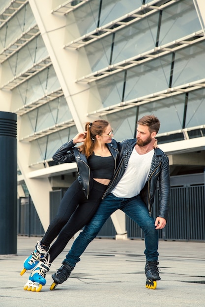 Casal lindo patinador com estilo hippie patinando depois da chuva.