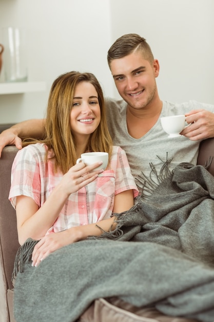 Casal lindo relaxando no sofá com café