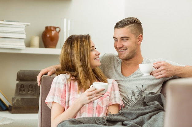 Casal lindo relaxando no sofá com café