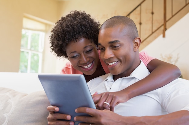 Casal lindo relaxando no sofá com tablet pc