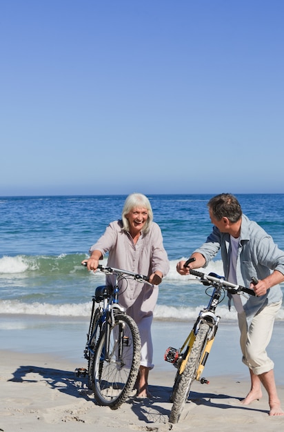 Casal maduro com suas bicicletas na praia