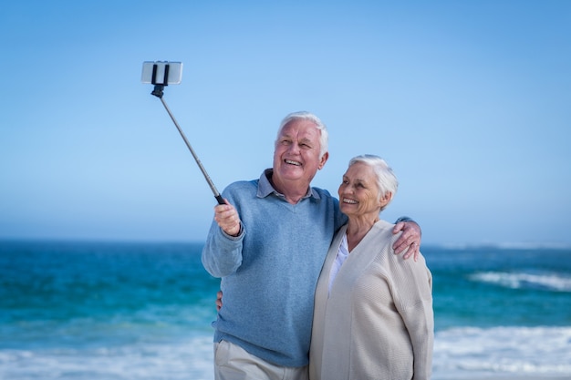 Casal maduro fofo tirando selfie com bastão de selfie