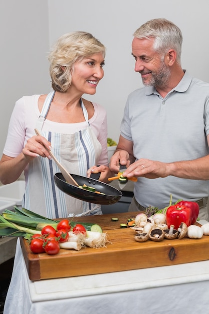 Casal maduro preparando comida juntos na cozinha