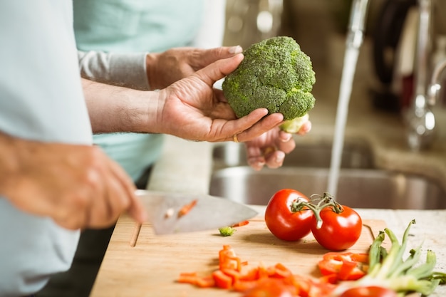 Casal maduro preparando vegetais juntos