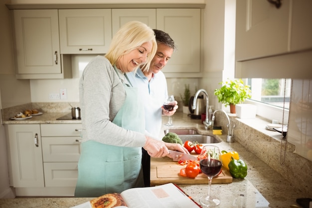 Casal maduro preparando vegetais juntos