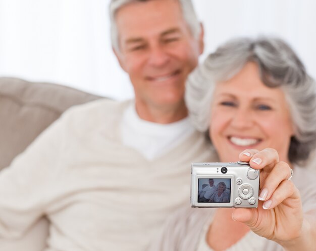 Casal maduro tomando uma foto de si mesmos em casa