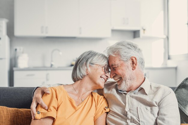 Casal mais velho rindo feliz conversando rindo em pé no interior de casa juntos abraçando com amor desfrutando de relacionamentos íntimos confiança apoio cuidado sentimento alegria ternuraxA