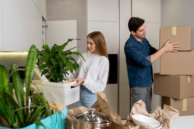 Foto casal manuseando caixas de pertences depois de se mudar para uma casa nova