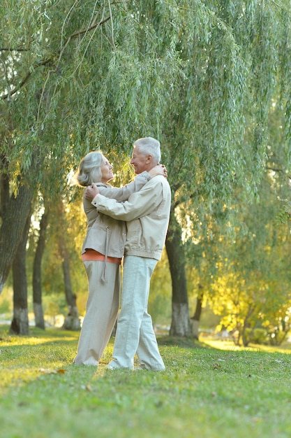 Casal maturo dançando no parque de outono