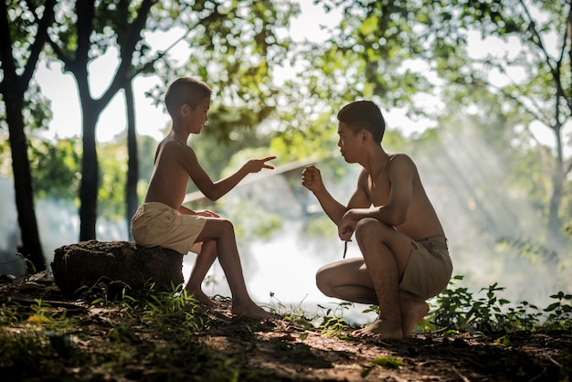 Casal menino jogando mão de símbolo de batalha nativa da Tailândia.