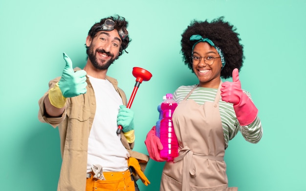 Casal misto se sentindo orgulhoso, despreocupado, confiante e feliz, sorrindo positivamente com o polegar para cima. conceito de limpeza. conceito de reparos domésticos