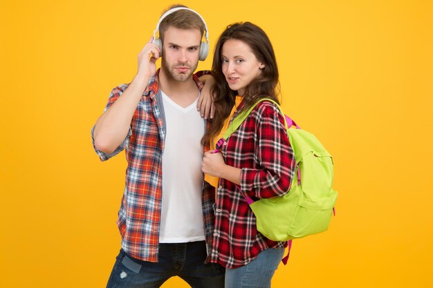 Casal moderno vestindo roupas combinando Conceito de look familiar Dia de compras Trendsetters Jovens lideram ideias de moda Estudantes de casal hipster Casal de estudantes na moda fundo amarelo