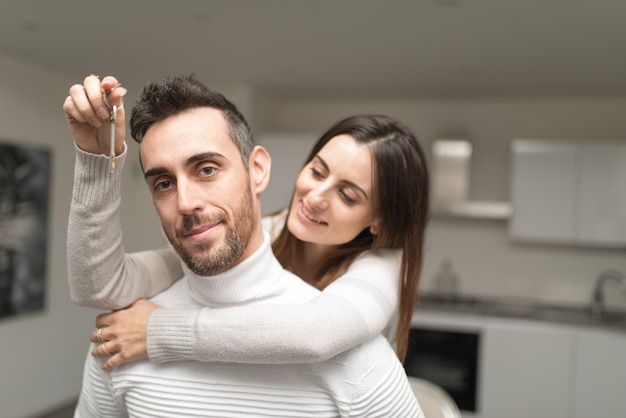 Casal mostrando as chaves da sua nova casa