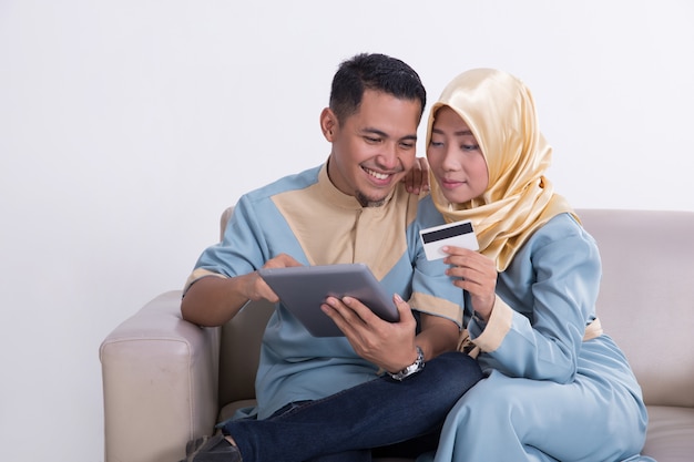 Casal muçulmano no sofá com tablet