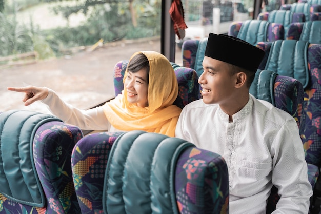 Casal muçulmano viaja de ônibus durante o feriado de eid mubarak para encontrar a família em casa