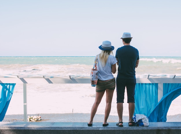 Casal mulher e homem olhando para o mar tempestuoso