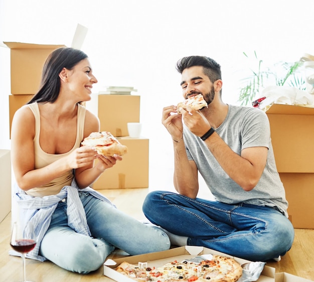 Foto casal mulher homem caixa casa casa mudando apartamento feliz juntos romântica realocação pizza comendo