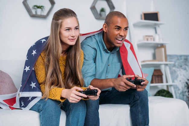 Casal multicultural jogando videogame em casa