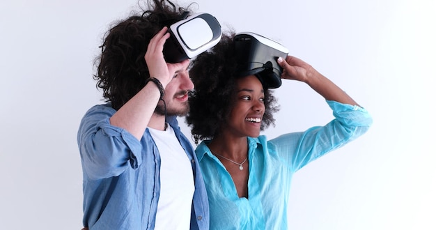 Casal multiétnico feliz obtendo experiência usando óculos de fone de ouvido VR de realidade virtual, isolado no fundo branco