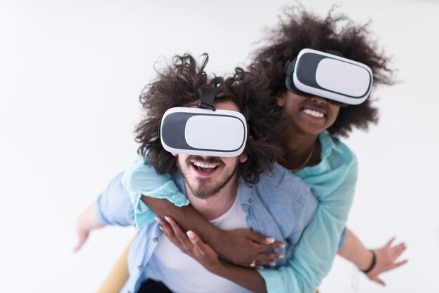 Casal multiétnico feliz obtendo experiência usando óculos de fone de ouvido VR de realidade virtual, isolado no fundo branco