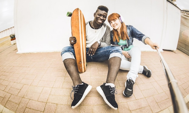 Casal multirracial apaixonado tomando selfie se divertindo juntos ao ar livre