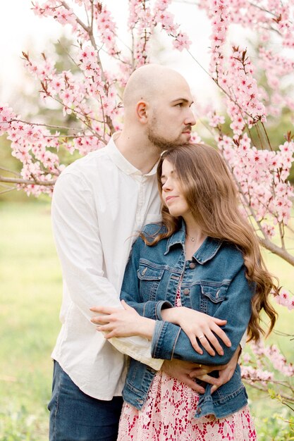 Casal na árvore florescendo rosa