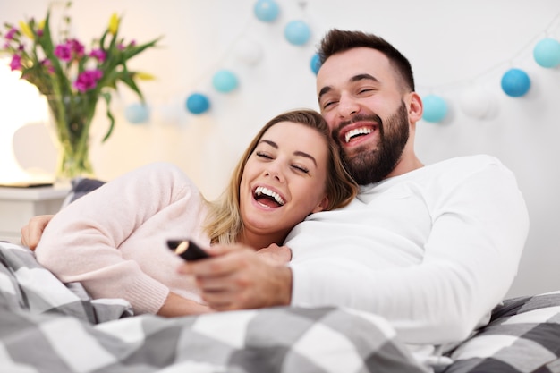 casal na cama assistindo tv