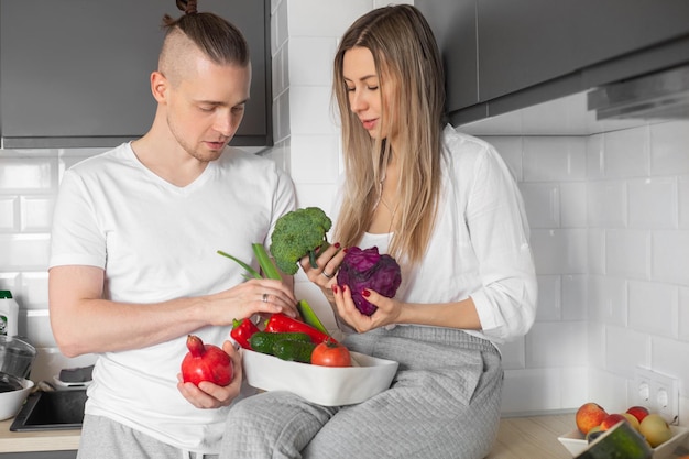 Casal na cozinha escolhendo legumes