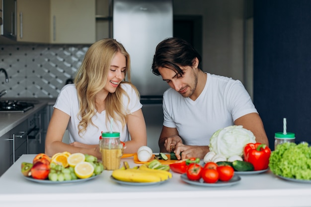 Casal na cozinha sentado à mesa com comida saudável. Homem, é, corte, um, vegetal